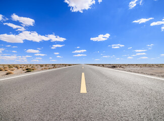Asphalt highway road and desert natural landscape under the blue sky. Outdoor road background.