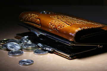 Close-up of an open wallet with coins spilling out