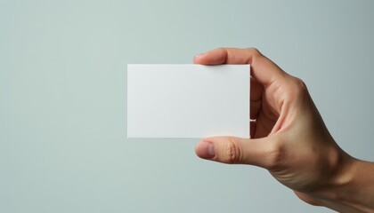 Fototapeta premium Business Card Mockup in Hand. Hand holding blank business card with copy space for branding on light background