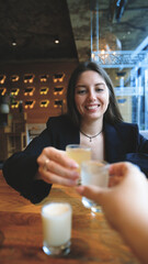A woman clinks glasses and drinks an alcoholic tincture - close-up