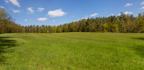 panorama of a field with green grass and blue sky in southern Germany
