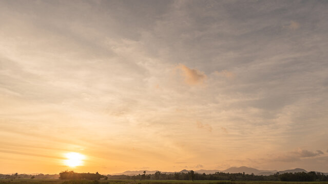 Sunset sky clouds in the evening with colorful orange sunlight over mountains in golden hour or Sunrise sky in the morning, Horizon Autumn landscape dusk sky backgrounds