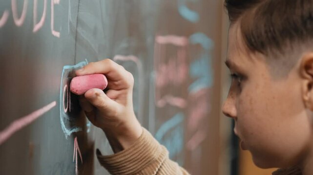 Closeup of smart student or boy writing prompt on blackboard. Child plan project and setting engineering system and brainstorm creative idea wrote on blackboard. Focus on hand. Site view. Erudition.