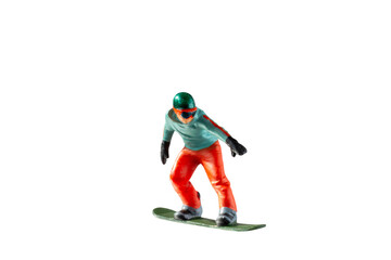 Miniature figurine depicting a snowboarder in mid-motion isolate on white background with clipping path