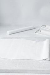 Rolled out white fondant on a marble countertop, fondant being prepared for use