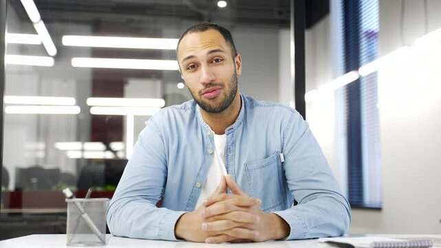 Webcam view. Confident african american businessman talking on a video call looking at camera sittingat workplace in business office. A young coach or tutor conducts an online training, class remotely