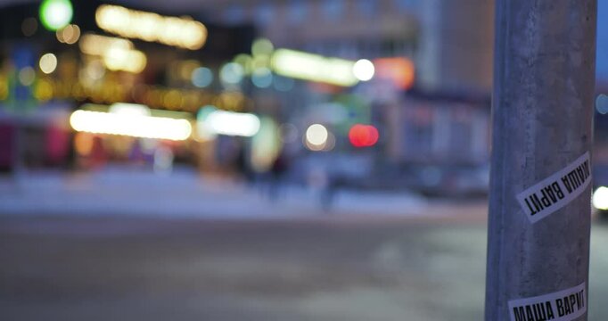 Night city. Out of focus. Cars with their headlights on drive along the road against the background of glowing windows of buildings.  Hand held. Siberia.
