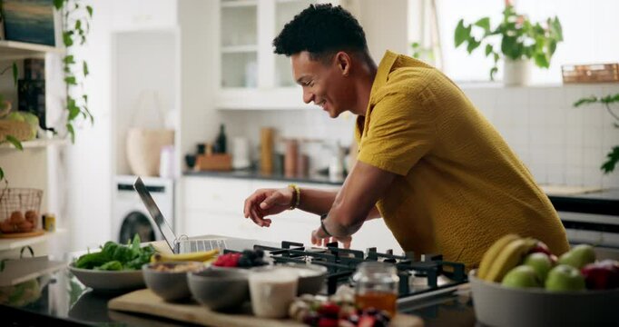 Happy man, cooking or kitchen with laptop for recipe, online tutorial or ingredients at home. Male person, freelance or browsing on computer or counter for research, food blog or hospitality at house