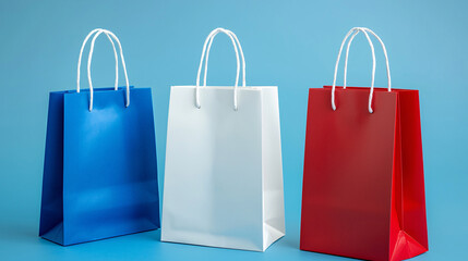 Three colorful shopping bags in blue, white, and red stand against a solid blue background, showcasing a vibrant and cheerful shopping theme.
