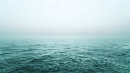 Obraz premium Serene teal ocean waves under a misty sky
