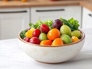 Fresh colorful fruits and greens in a bowl on a kitchen countertop.