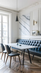 Salle à manger lumineuse avec table en marbre et banquette capitonnée bleue.