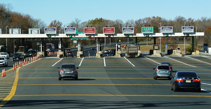 Robbinsville, New Jersey, U.S.A - Nov 9, 2024 - Traffic flows through a toll plaza, with signs indicating E-ZPass and closed lanes