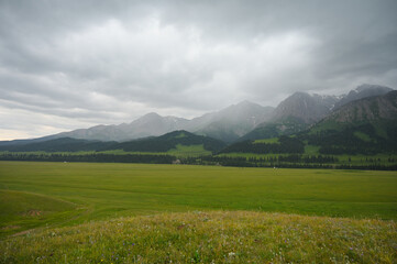 Mountains views of meadows and rivers on a summer cloudy day , Kazakhstan, Kegen, Aktas mount, Tekes river.