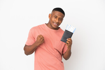 Young latin man isolated on white background happy in vacation with passport and plane tickets