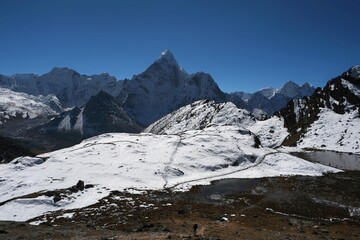 Amazing view on trekking from Dingboche to Lobuche through Kongma La Pass 5535 m. Little silhouette of trekking person on snow. Ama Dablam Mount in background. Everest Base Camp trek. Himalayas, Nepal
