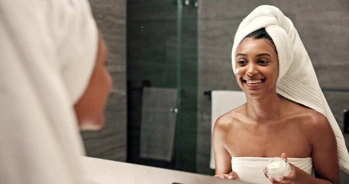 Happy woman, lotion and skincare with mirror in bathroom for rejuvenation, grooming or smooth skin at home. Female person, hygiene or facial with smile for face cream, SPF or moisturizer at house