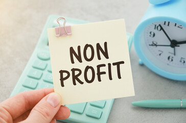 Businessman Holding Small White Signage Showing Non Profit Texts.