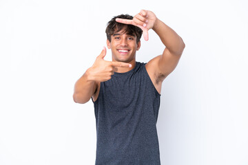 Naklejka premium Young sport caucasian man isolated on white background focusing face. Framing symbol