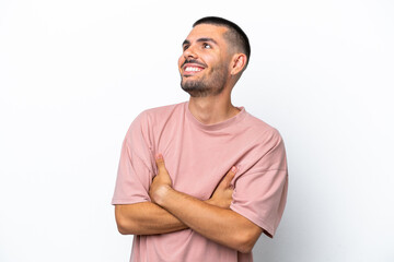 Fototapeta premium Young caucasian man isolated on white background looking up while smiling