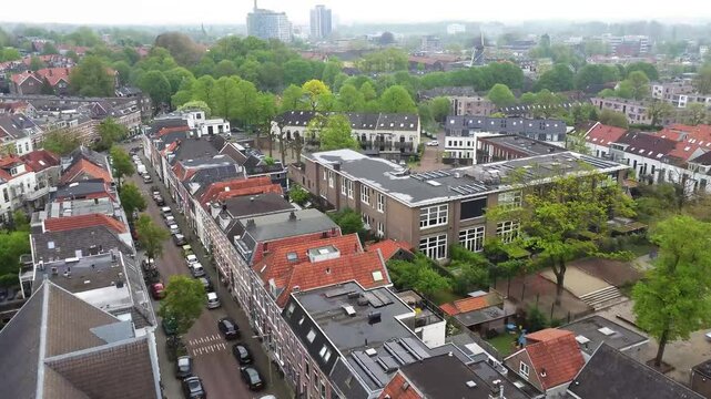 Drone footage of the Dutch city of Arnhem. Flying over the neighborhood Graaf Ottoplein E.O. towards a playground. In the background highrises in the citycentre can be seen.