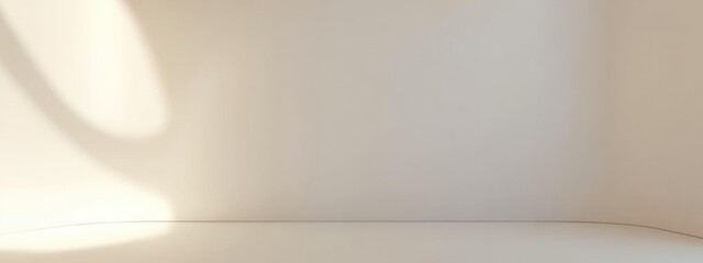 Minimalist beige wall with soft light and shadows.