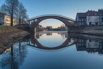 Fototapeta premium Stone Arch Bridge Reflecting in Calm River Water