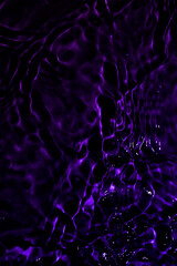 Vibrant purple reflections on water create a mesmerizing abstract pattern.