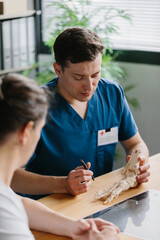 Physician demonstrating a foot model while discussing treatment options with a patient.