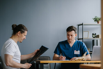 Physician showing an X-ray to a patient for diagnosis.