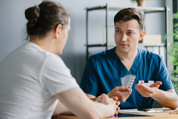 Doctor offering a selection of three blister packs of tablets to a patient