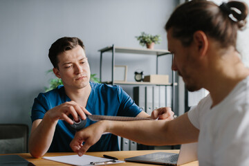 Orthopedic doctor preparing to apply kinesiology tape on a patient's arm.