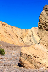 Obraz premium A rocky hillside with a large rock in the foreground