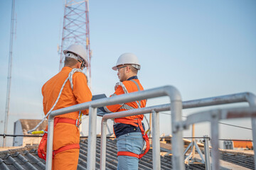 Telecommunication Engineers Working on 5G Tower,Technicians Climbing High Telecom Poles,Ensuring Network Maintenance with Safety Equipment