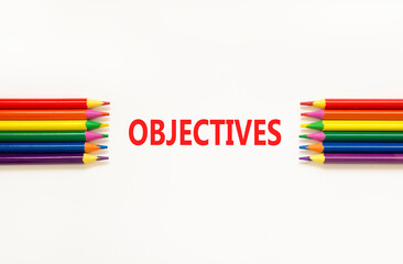 Objectives symbol. Concept word Objectives on beautiful white paper. Beautiful white paper background. Beautiful colored pencils. Business objectives concept. Copy space.