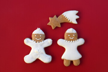 Smiling gingerbread man, woman and comet on a red background. Christmas time