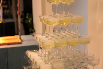 Towering pyramid of champagne glasses filled with bubbly