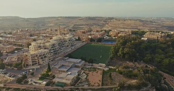 Football stadium in the urban landscape of a city in Malta aerial view. Cityscape architecture of the city on the island. High quality 4k footage
