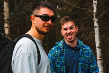 Two men in sunglasses and plaid shirts are making funny faces