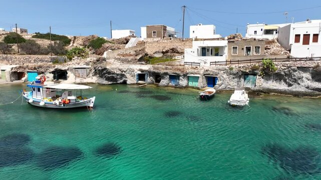 Aerial drone video of picturesque seaside area and bay of Goupa - Karra with colourful boat houses and elephant rock a perfect place to swim, Kimolos island, Cyclades, Greece