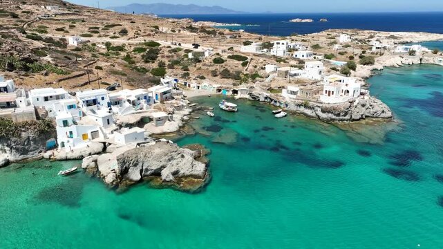 Aerial drone video of picturesque seaside area and bay of Goupa - Karra with colourful boat houses and elephant rock a perfect place to swim, Kimolos island, Cyclades, Greece