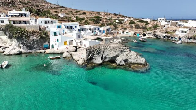 Aerial drone video of picturesque seaside area and bay of Goupa - Karra with colourful boat houses and elephant rock a perfect place to swim, Kimolos island, Cyclades, Greece