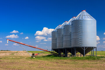 A large silo with a conveyor belt in front of it