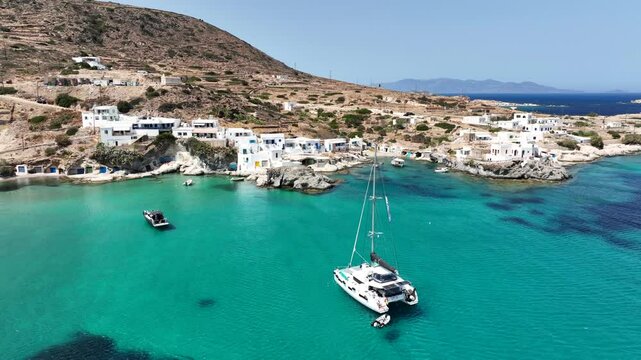 Aerial drone video of picturesque seaside area and bay of Goupa - Karra with colourful boat houses and elephant rock a perfect place to swim, Kimolos island, Cyclades, Greece