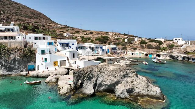 Aerial drone video of picturesque seaside area and bay of Goupa - Karra with colourful boat houses and elephant rock a perfect place to swim, Kimolos island, Cyclades, Greece