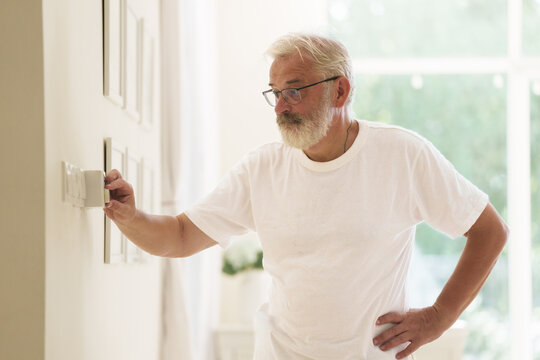 Man adjusting thermostat. Home temperature.