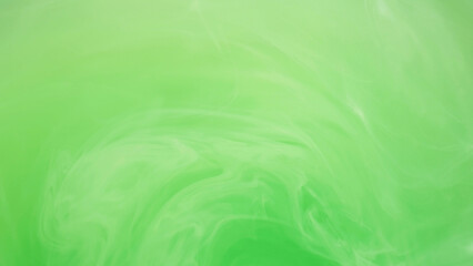 Light emulsion. Liquid paint. Defocused bright green color cloud ink mist vortex vapor steam moving...