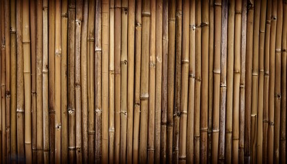 Fototapeta premium An image of rustic bamboo pieces aligned vertically, offering a natural and textured background suitable for eco-friendly design themes or construction inspiration emphasizing sustainable materials.