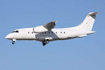 A Small White Jet Airplane arriving in bright evening light