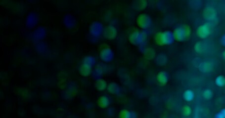 Bokeh confetti. Flare sparks. Colorful yellow green red purple flicker round gleaming blinking lens flickers on abstract blurred light background.